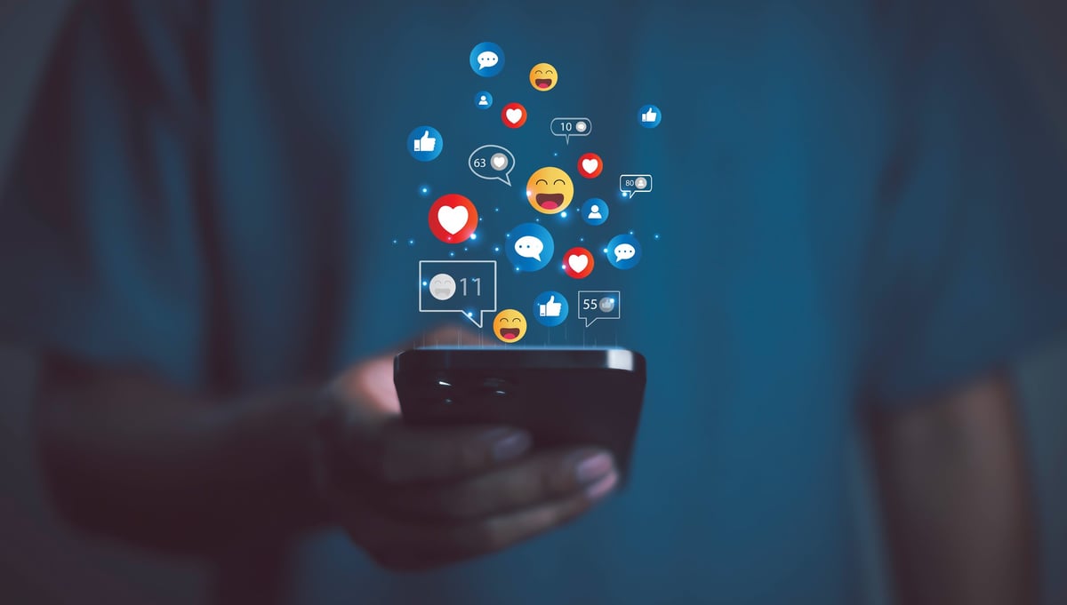 Persona usando smartphone con íconos de redes sociales — Facebook e Instagram Ads que capturan la atención